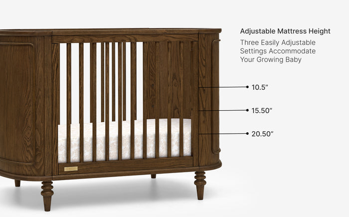 Wooden crib with adjustable mattress height settings on a white background