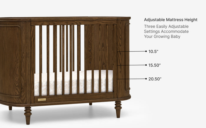 Wooden crib with adjustable mattress height settings on a white background