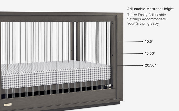 Baby crib with checkered mattress and safety certification labels on a white background