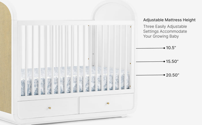 White crib with adjustable mattress height settings labeled on a white background