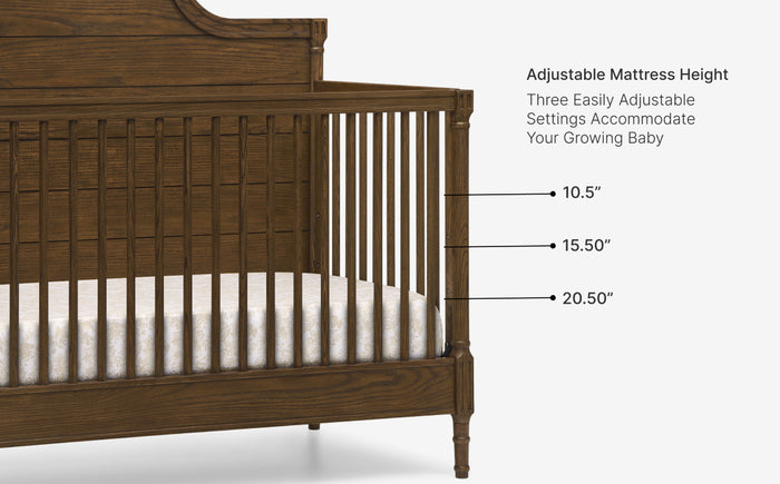 Wooden crib with adjustable mattress height settings on a white background