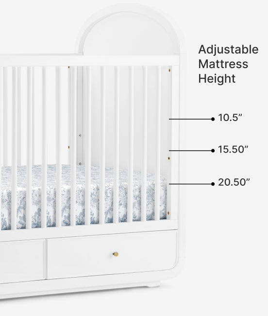 White crib with adjustable mattress height labels on a white background