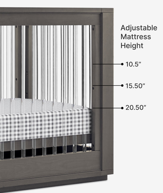 Crib with adjustable mattress height labels on a white background