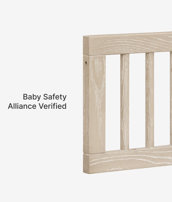 Wooden crib with 'Baby Safety Alliance Verified' label on a white background