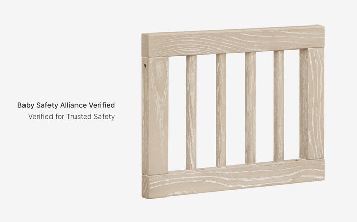 Wooden crib with 'Baby Safety Alliance Verified' label on a white background