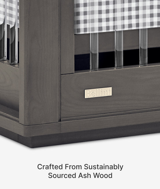 Gray wooden crib with checkered curtains and a visible brand logo on a white background.