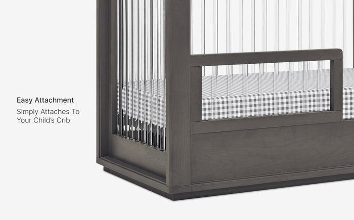 Crib with a safety gate attached on a white background