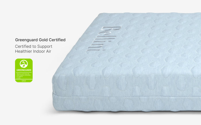 Blue mattress with Greenguard Gold certification label on a white background