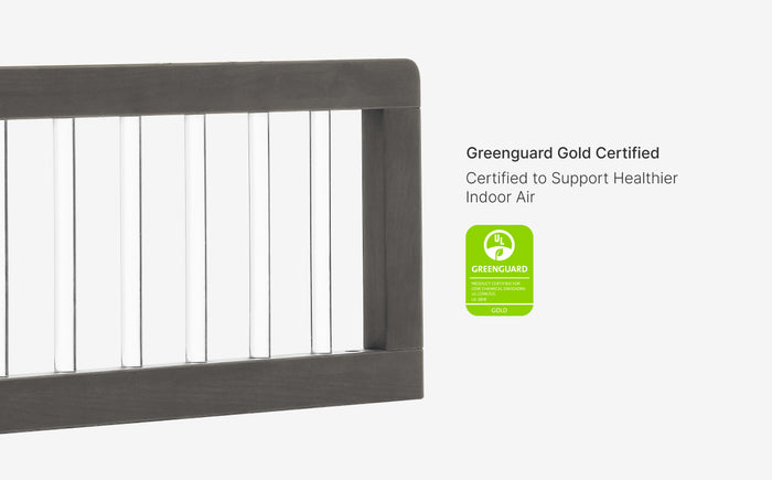 Gray crib with Greenguard Gold certification label on a white background