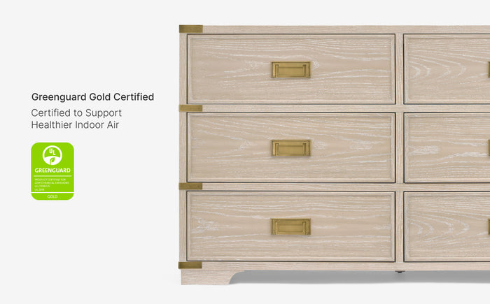 Wooden dresser with gold accents and Greenguard Gold certification label on a white background