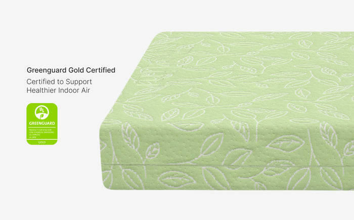 Green mattress cover with leaf pattern and Greenguard Gold certification label on a white background