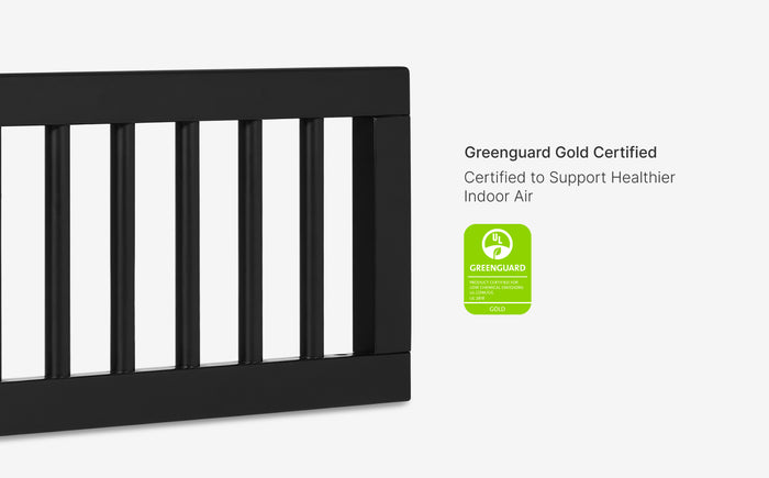 Black crib with Greenguard Gold certification label on a white background
