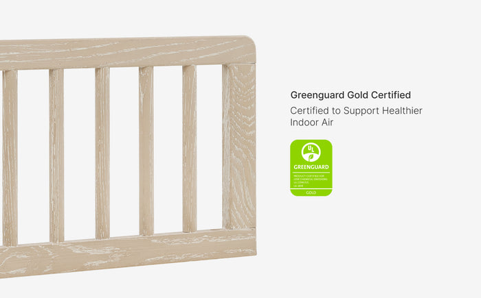 Wooden crib with Greenguard Gold certification label on a white background