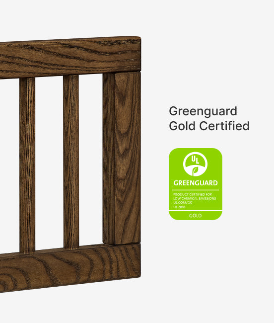 Wooden crib with Greenguard Gold Certified label on a white background
