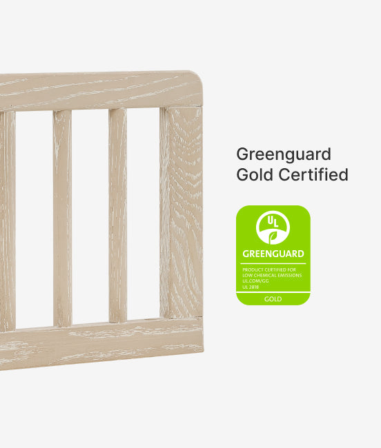 Wooden crib with Greenguard Gold Certified label on a white background