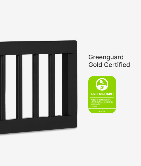 Black crib with Greenguard Gold certification label on a white background
