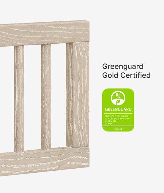 Wooden crib with Greenguard Gold Certified label on a white background