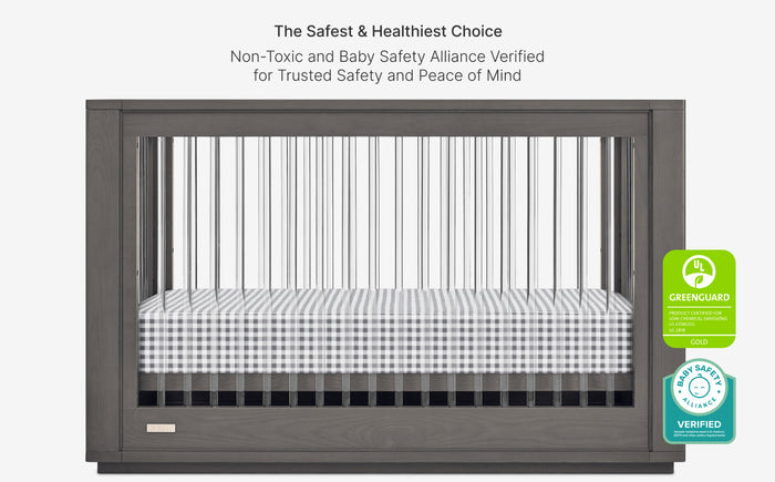 Gray crib with checkered mattress cover on a white background, featuring safety certification logos.