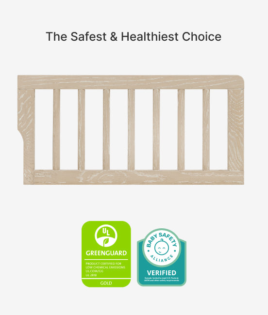 Wooden baby crib with Greenguard Gold and Baby Safety Alliance verified badges on a white background.