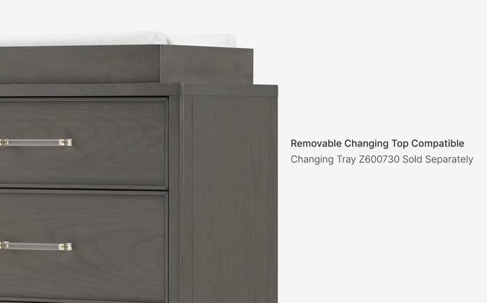 Gray wooden changing table with text indicating a removable top is compatible with a separate tray.