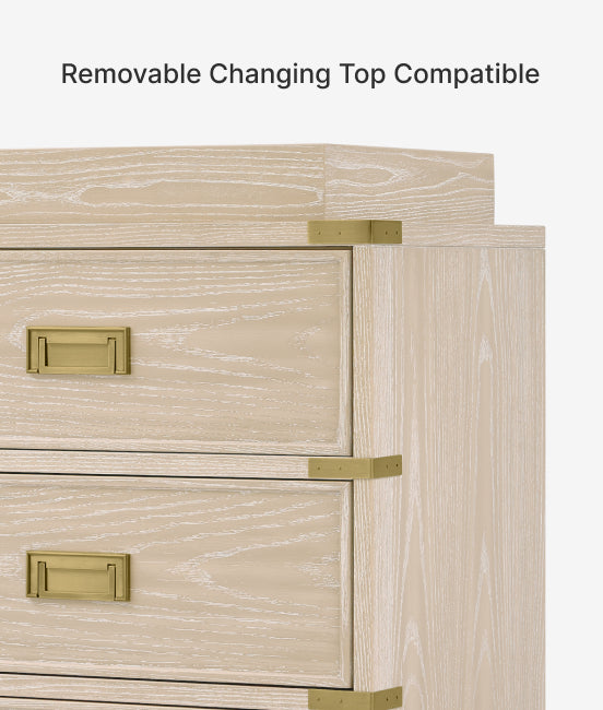 Wooden cabinet with gold handles and text indicating removable changing top compatibility.