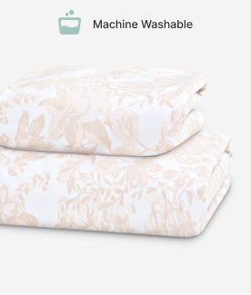 Folded fabric with a subtle pattern on a light background, indicating machine washability.