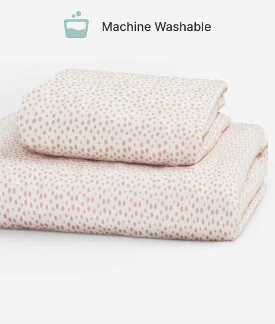 Folded bed sheets with a subtle pattern on a white background, labeled 'Machine Washable'.