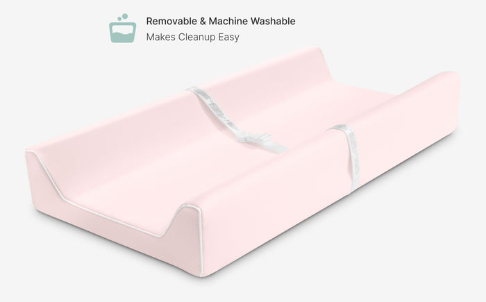 Pink mattress protector with text indicating it is removable and machine washable.