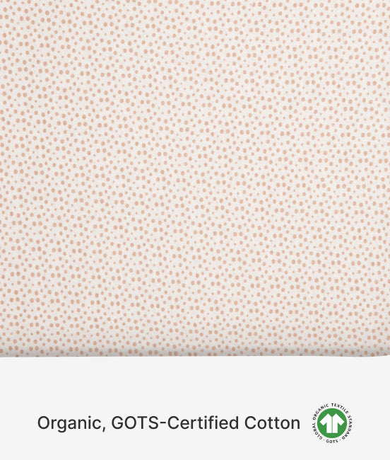 Patterned fabric with small dots on a light background, featuring GOTS certification logo.