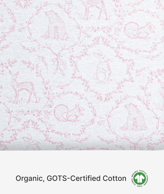 Patterned fabric with pink designs on a white background, featuring GOTS certification logo.