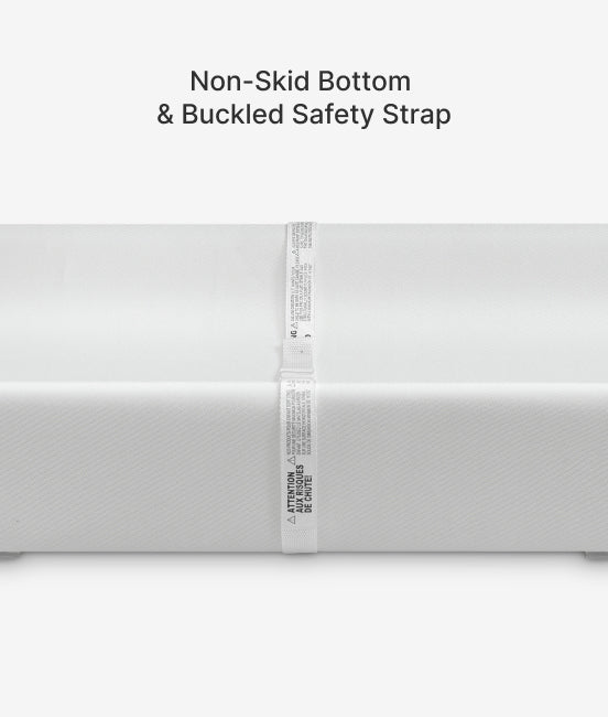 White mattress with non-skid bottom and buckled safety strap on a white background