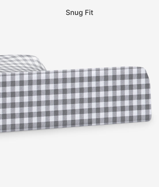Gray and white checkered fitted sheet on a mattress with 'Snug Fit' text above.