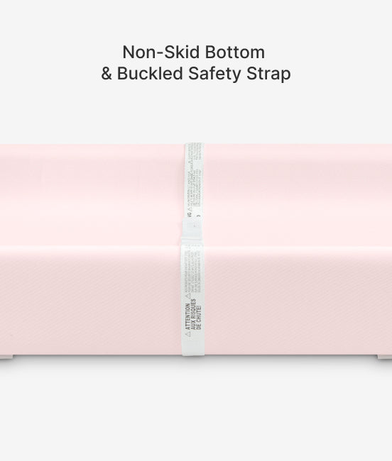 Pink blanket with a non-skid bottom and buckled safety strap on a white background