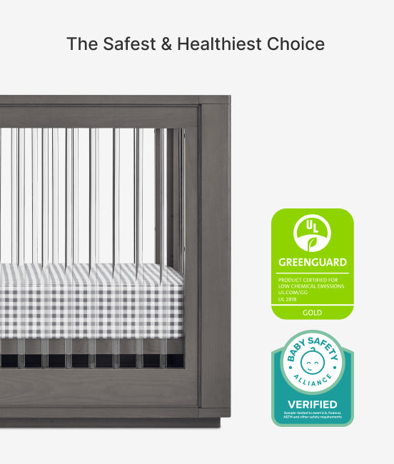Crib with checkered mattress and Greenguard and Baby Safety verified logos on a white background