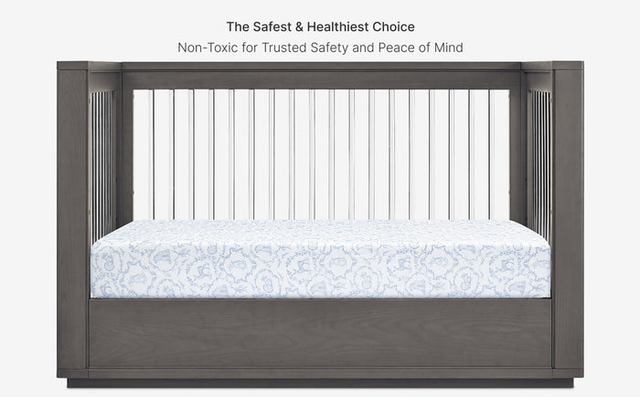 Gray crib with mattress and text about safety and healthiness on a white background