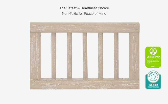 Wooden crib with safety bars and GreenGuard certification logo on a white background