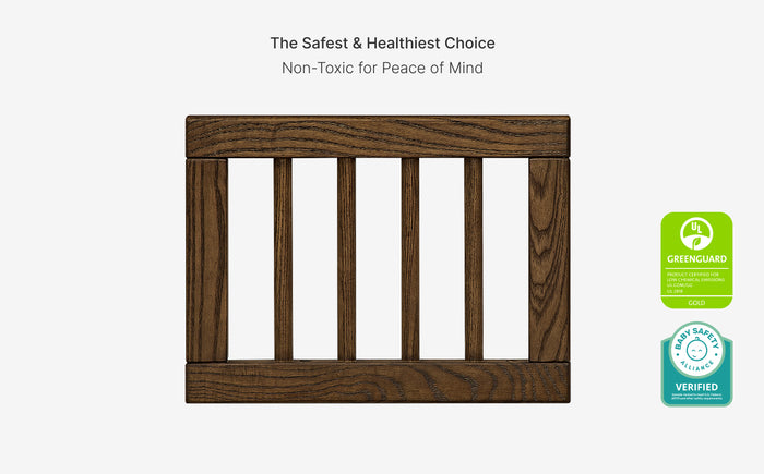 Wooden crib rail with green certification labels on a white background