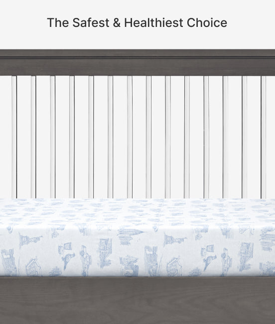 Crib with a fitted sheet featuring blue baby illustrations on a white background.