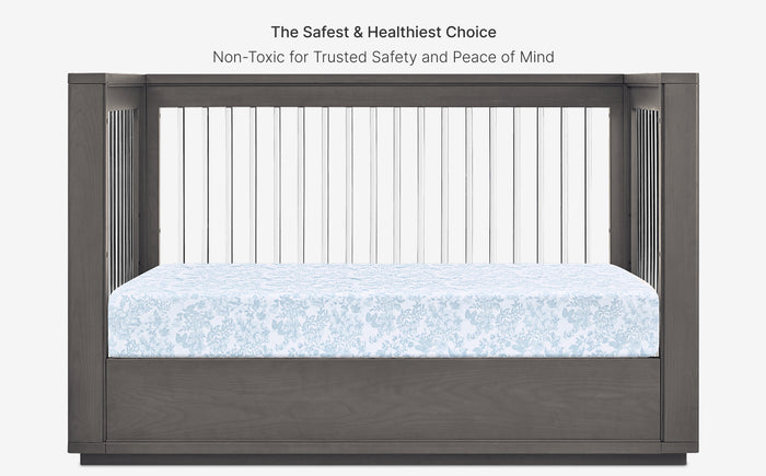 Gray crib with white mattress and text about safety and healthiness on a white background
