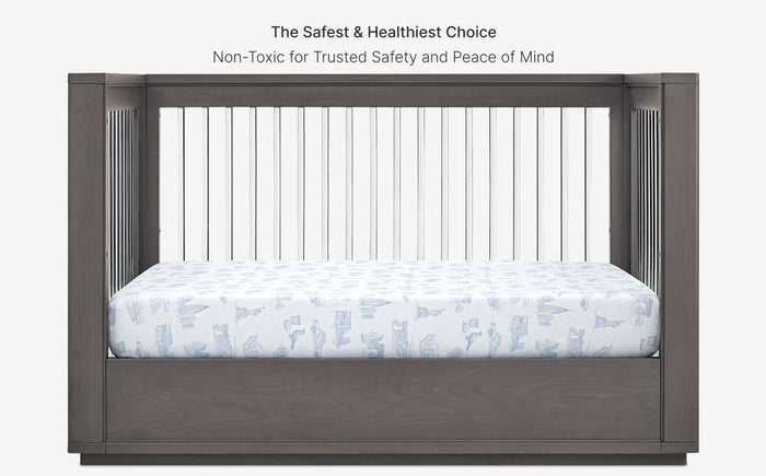 Gray crib with mattress featuring animal patterns on a white background